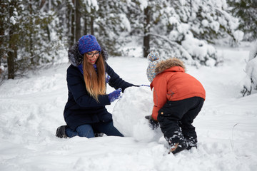 Fototapeta na wymiar winter fun. a girl and a boy making snowballs.