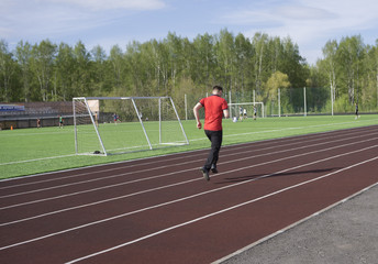 Young man in doing exercise. at the stadium