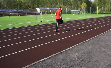 Young man in doing exercise. at the stadium