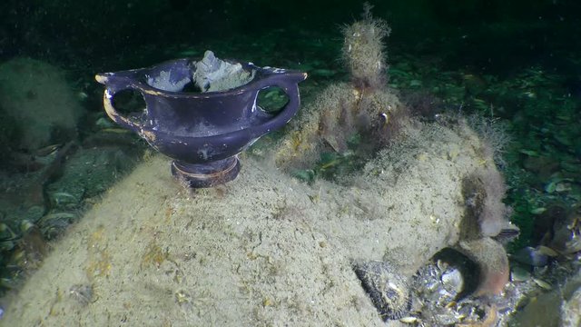 Underwater archeology: Ancient Greek Black-glazed ware on the seabed, kantharos, medium shot.
