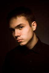 Fototapeta premium młody chłopak na ciemnym tle studio