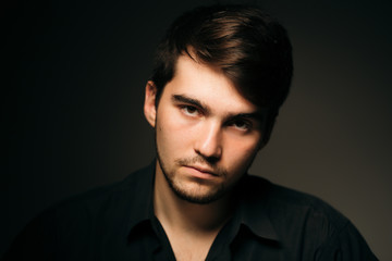 young brunette guy on a dark background