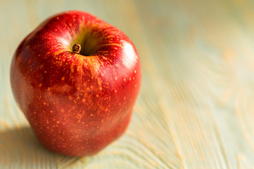 Red juice ripe apple on wooden background
