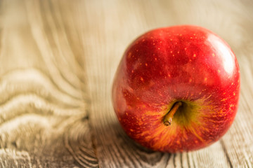 Red juice ripe apple on wooden background