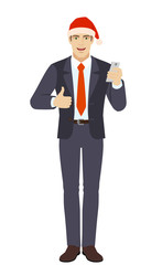 Businessman in Santa with mobile phone showing thumb up