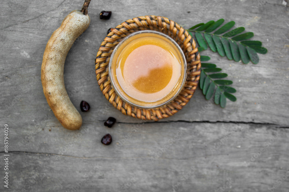 Wall mural Tamarind and tamarind juice with honey on wooden background