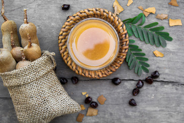 Tamarind and tamarind juice with honey on wooden background