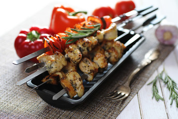 Kebab cooked on metal skewers with vegetables