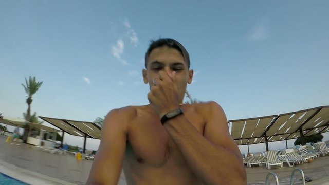 A cheery view of a young man diving underwater among numerous air bubbles rolling around him on aTurkish resort in slow motion