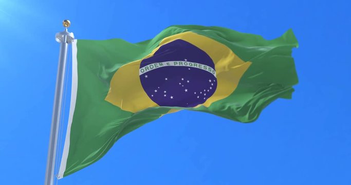 Flag of Brazil waving at wind in slow with blue sky, loop