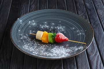 Appetizer for reception. Fresh banana, orange, kiwi, strawberry on skewer