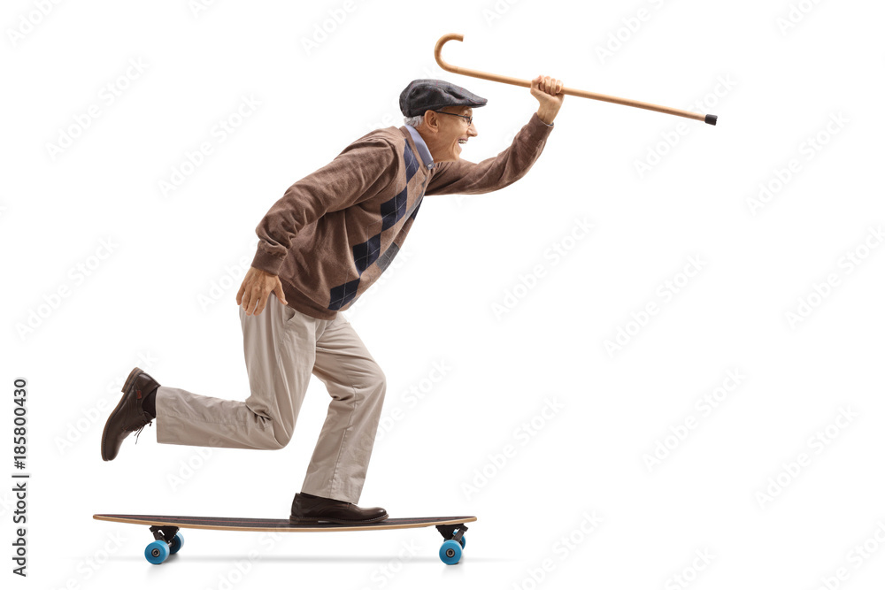 Wall mural Joyful senior holding a cane and riding a longboard