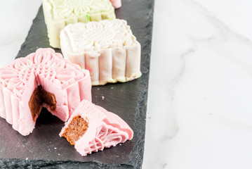 Asian, Japanian food,  Traditional sweet dessert multicolored no bake snow skin mooncakes on white marble table. copy space