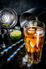 Cuba Libre, long island or iced tea cocktail with strong alcohol, cola, lime and ice, two glass, dark background copy space