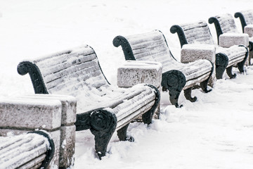 Row of white shops for sitting with urns in winter.