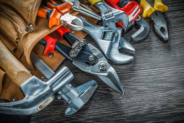 Leather building belt with construction tools on wooden board