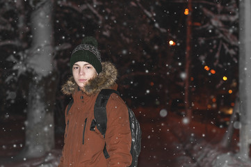 young man on a city street during a snowfall