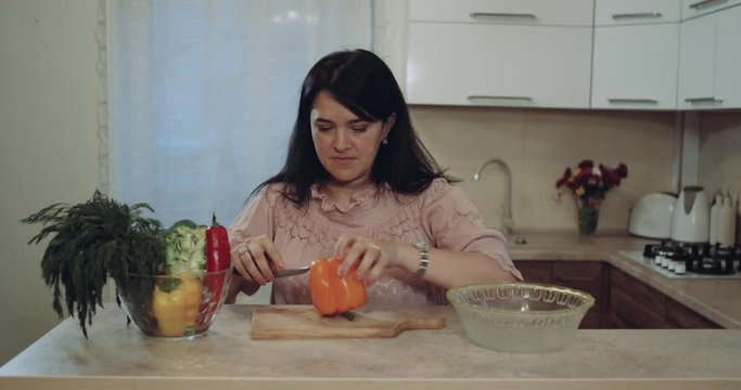 Woman in the kitchen strat to cut vegetables. 4k