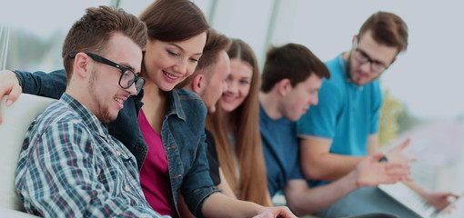 group of students sitting in the lobby of the University, and to