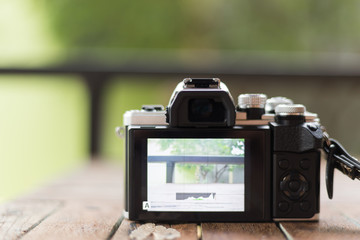 Mirrorless camera white and black color on a old wooden Board
