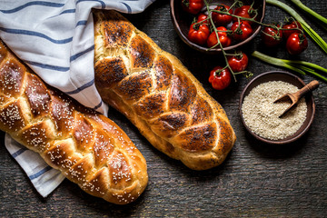 Challah is a Jewish bread to the feast on the dark wooden boards.