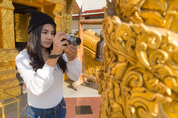 Fototapeta na wymiar Asian woman taking photo with mirrorless camera at Buddhist Temple