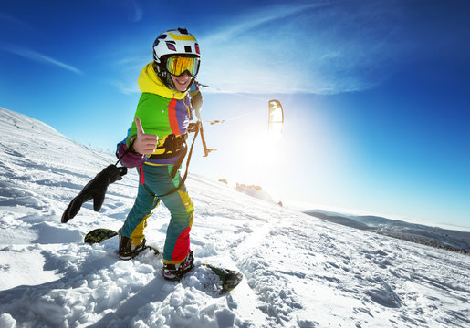 Happy lady snowboarder with snow kite