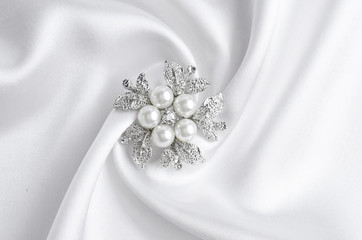 silver brooch flower with pearl on silk - obrazy, fototapety, plakaty