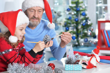 grandfather with girl preparing for Christmas 