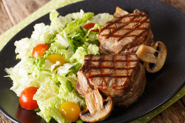 Roasted fillet mignon steak with fried mushrooms and fresh vegetable salad close-up. horizontal