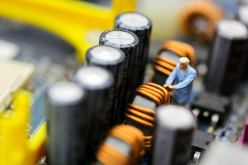 Miniature people : engineer and worker working on computer mainboard bitcoin concept.