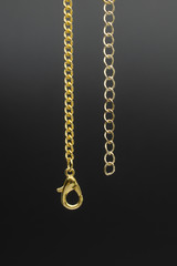 Gold chain detail clasp isolated on black