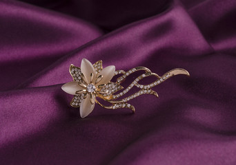 gold brooch flower with gems and moon stone on silk