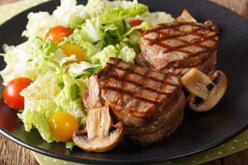 Delicious filet minion steak with fresh vegetable salad and mushrooms close-up. horizontal