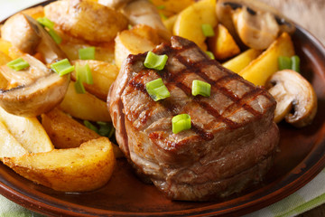 Grilled fillet mignon with potatoes and mushrooms close-up. horizontal