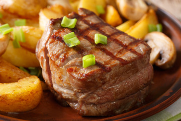 delicious filet mignon with potatoes and mushrooms macro on a plate. horizontal
