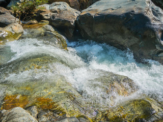 Naklejka na ściany i meble Mountain fast flowing river stream of water in the rocks