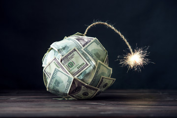 Bomb of money hundred dollar bills with a burning wick. Little time before the explosion. Concept...