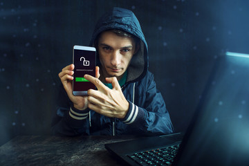 Male hacker is trying to access the phone. Security and protection of personal data. Concept of...