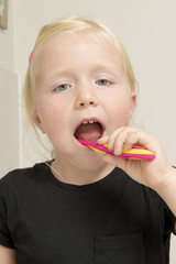 Little Girl in Black Shirt Toothbrushing in Bathroom