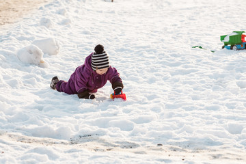 Fototapeta na wymiar Kid plays on the snow