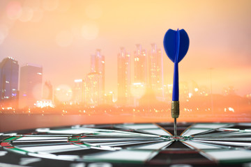 dart on board with  city scape background, concept as success and goal.