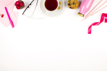 Flatlay with pink note paper, glasses, muffin, cup of tea and bottle of juice. Concept of healthy lunch at work. Lifestyle flatlay