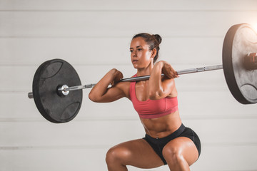 Muscular fitness woman deadlift a barbell over his head cross fit in the gym. Sports, cross fit and fitness - concept of healthy lifestyle. Woman in the fitness club. Cross fit woman. Cross fit style.