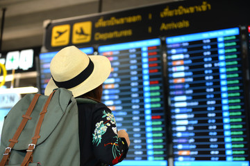 Tourist is checking Arrival & Departure flight time table at the Airport.