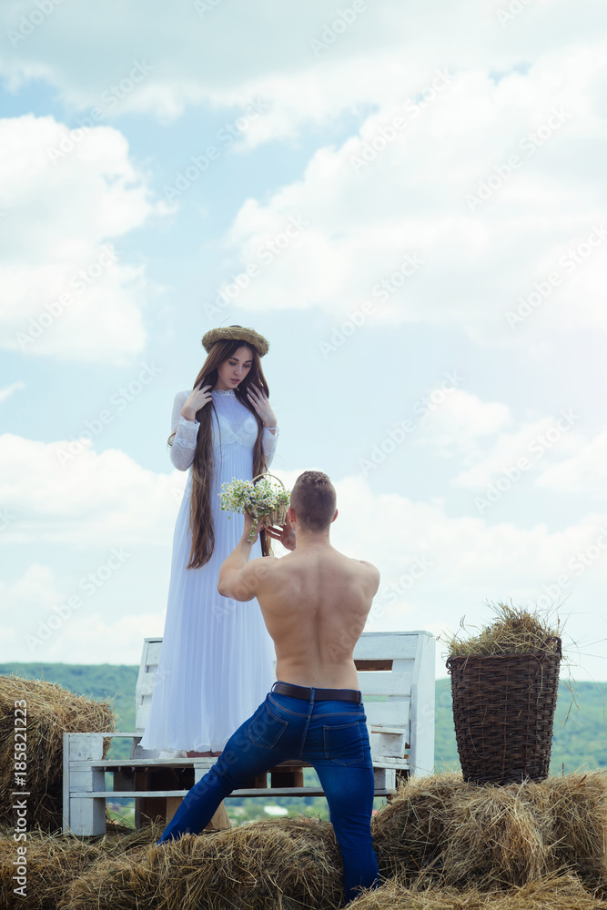 Wall mural man give flowers to woman on bench