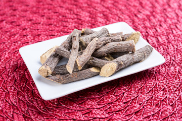 Pile of licorice roots on a cloth background