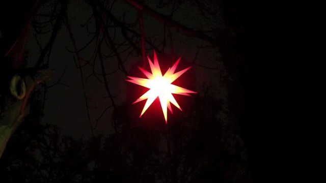 Herrnhuter Weihnachtsstern bewegt sich im Wind in der Nacht, wird herangezoomt,  Video Full HD 1080