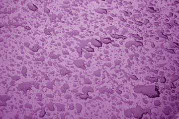 Water drops on metal surface in purple color.