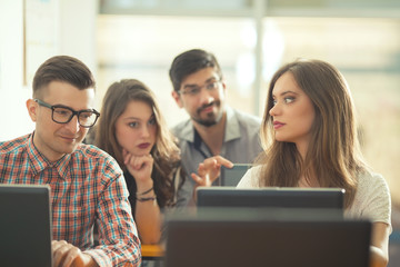 Team of university students is working together on a school project in the computer lab